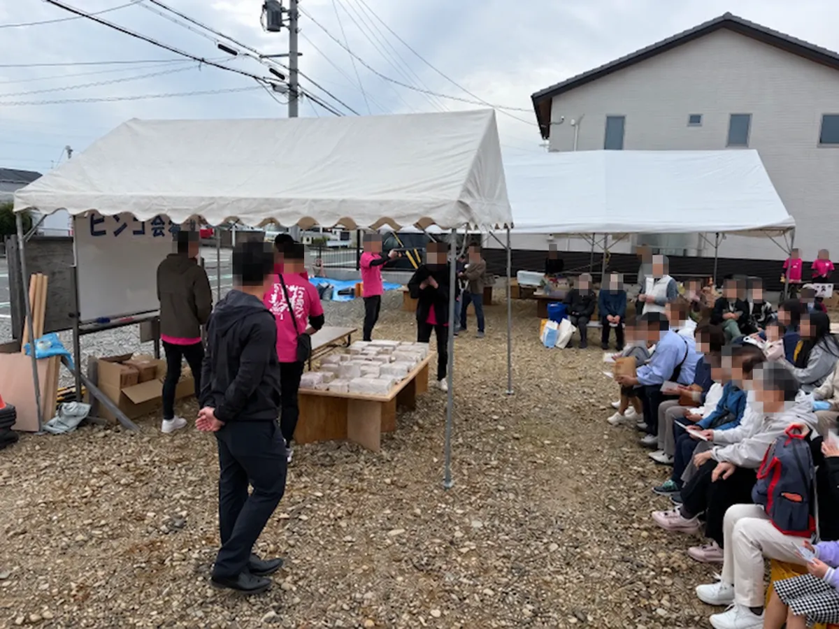 屋外のテントで集まっている参加者の様子