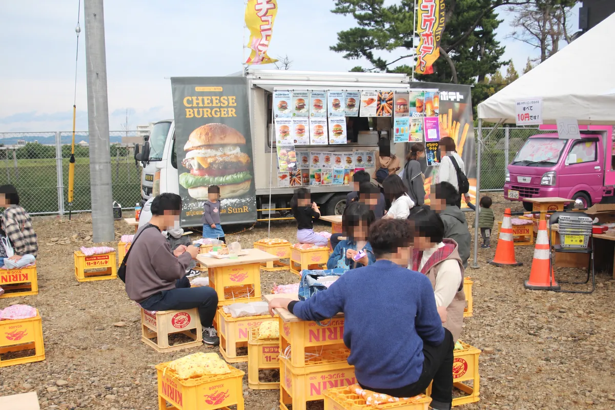 キッチンカーの前で食事を楽しむ人々